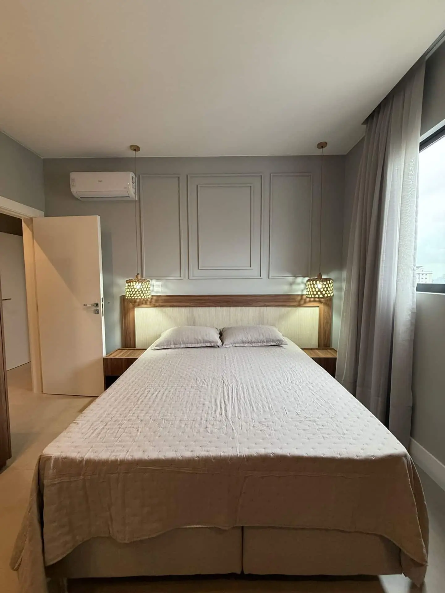 Cama de casal com cabeceira estofada, abajures e ar-condicionado