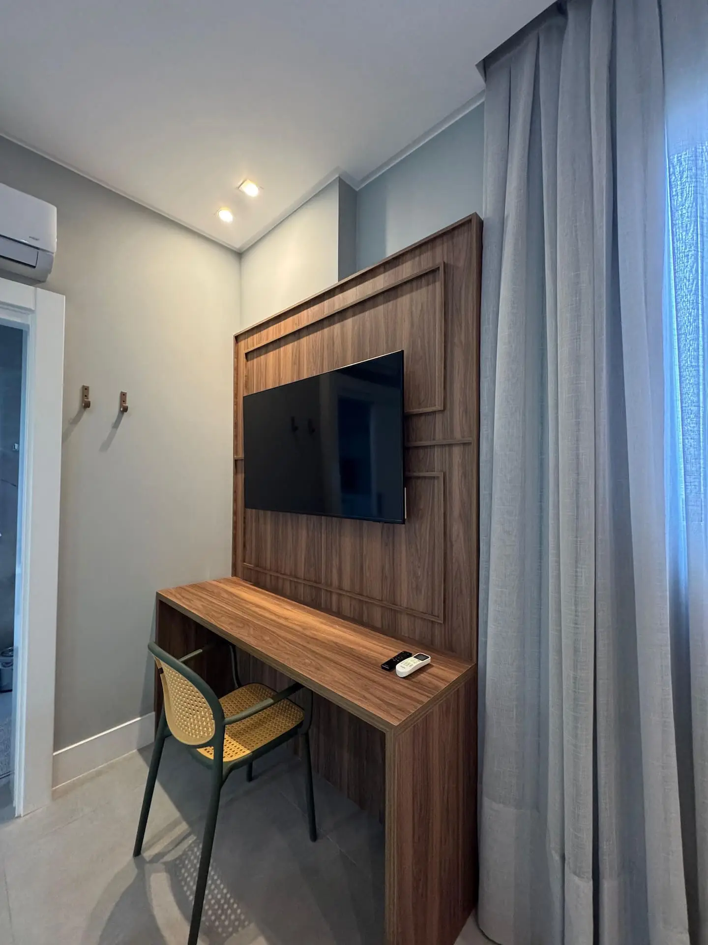 Mesa de trabalho com TV na parede de madeira