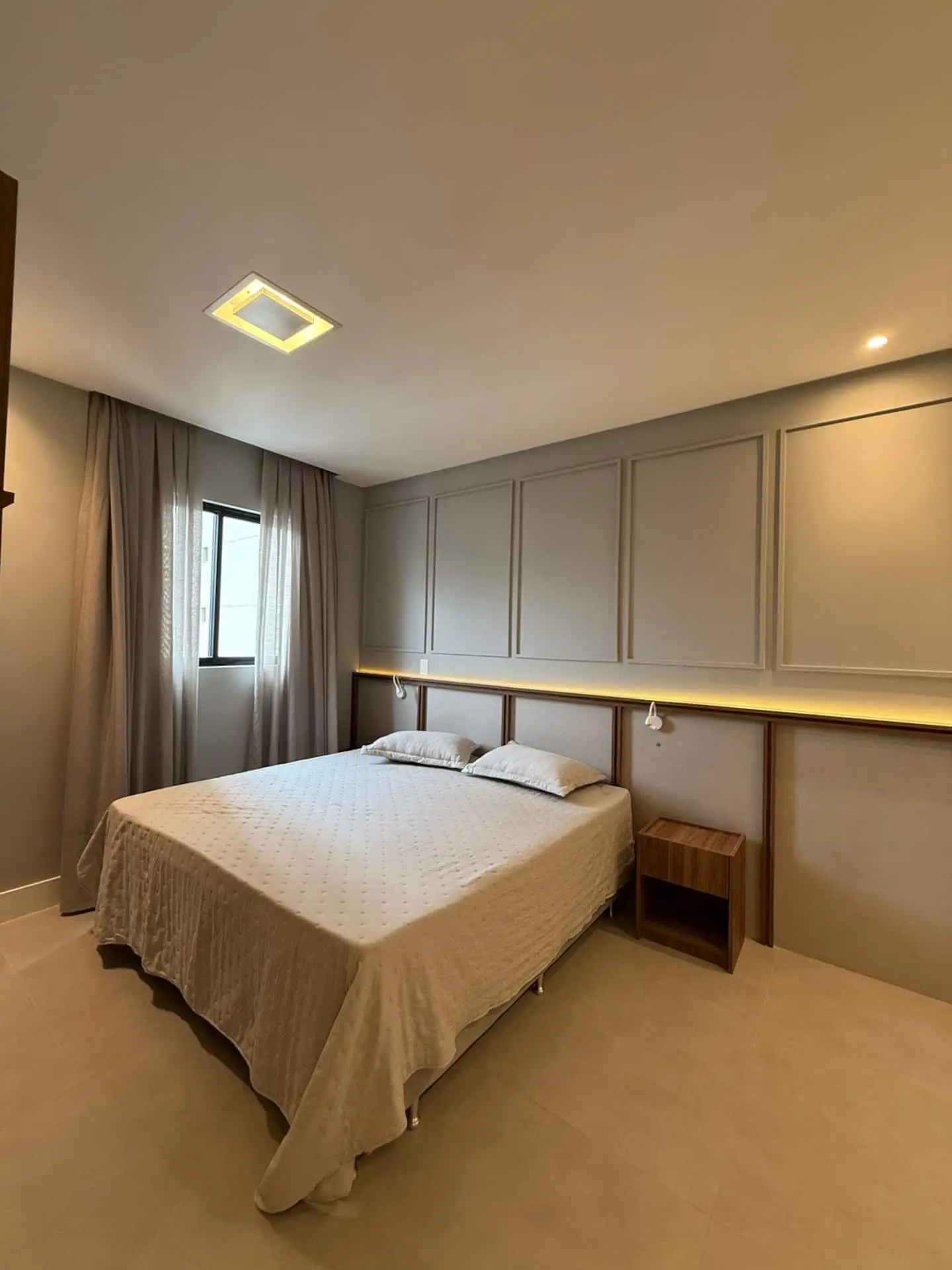 Cama de casal com faixa de luz na parede